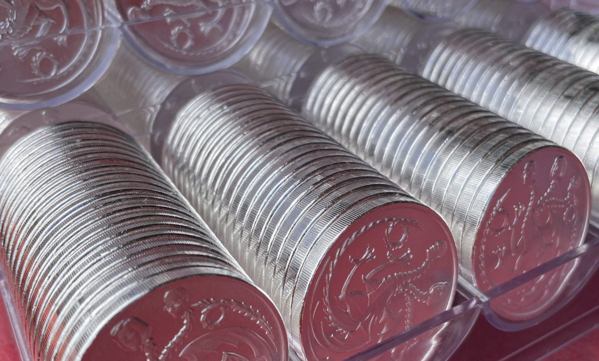 Tubes of privately minted silver rounds stacked on a bench